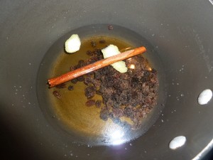 Creamy Rice Pudding - add the cinnamon stick, raisins, lemon peeel and water to a pot